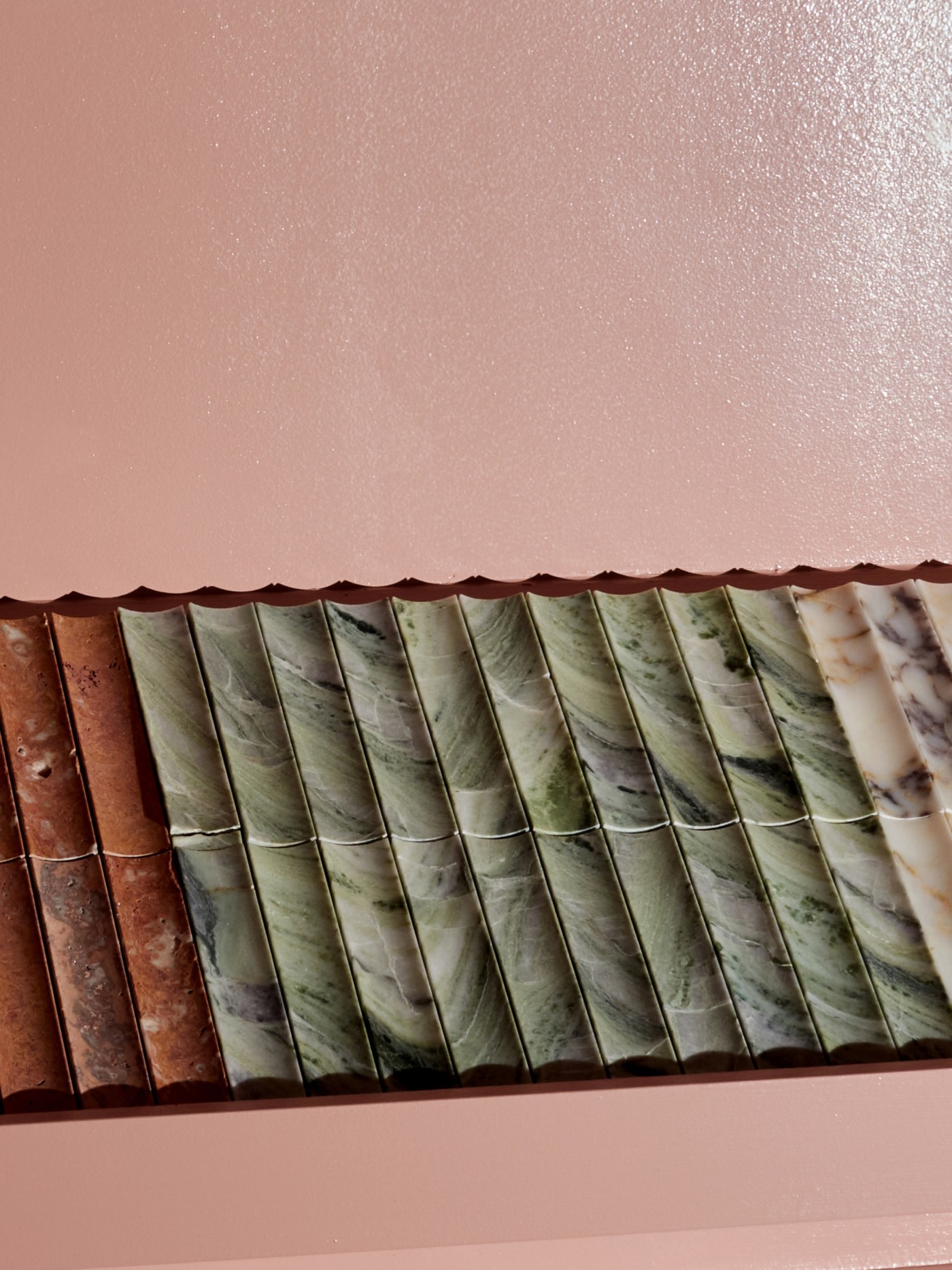 a row of marble tiles on a pink wall.