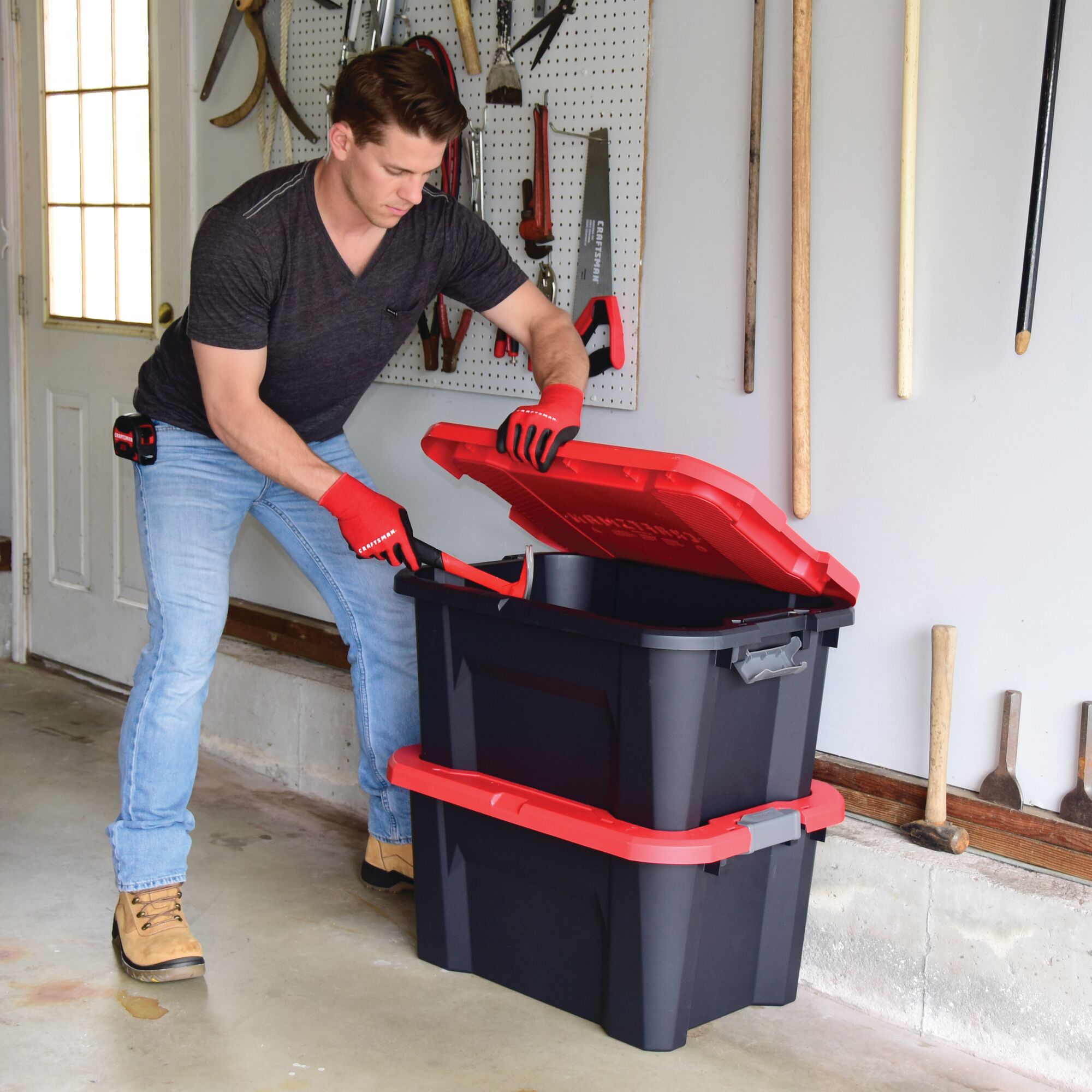 20 Gallon latching tote being used by a person to store tools.