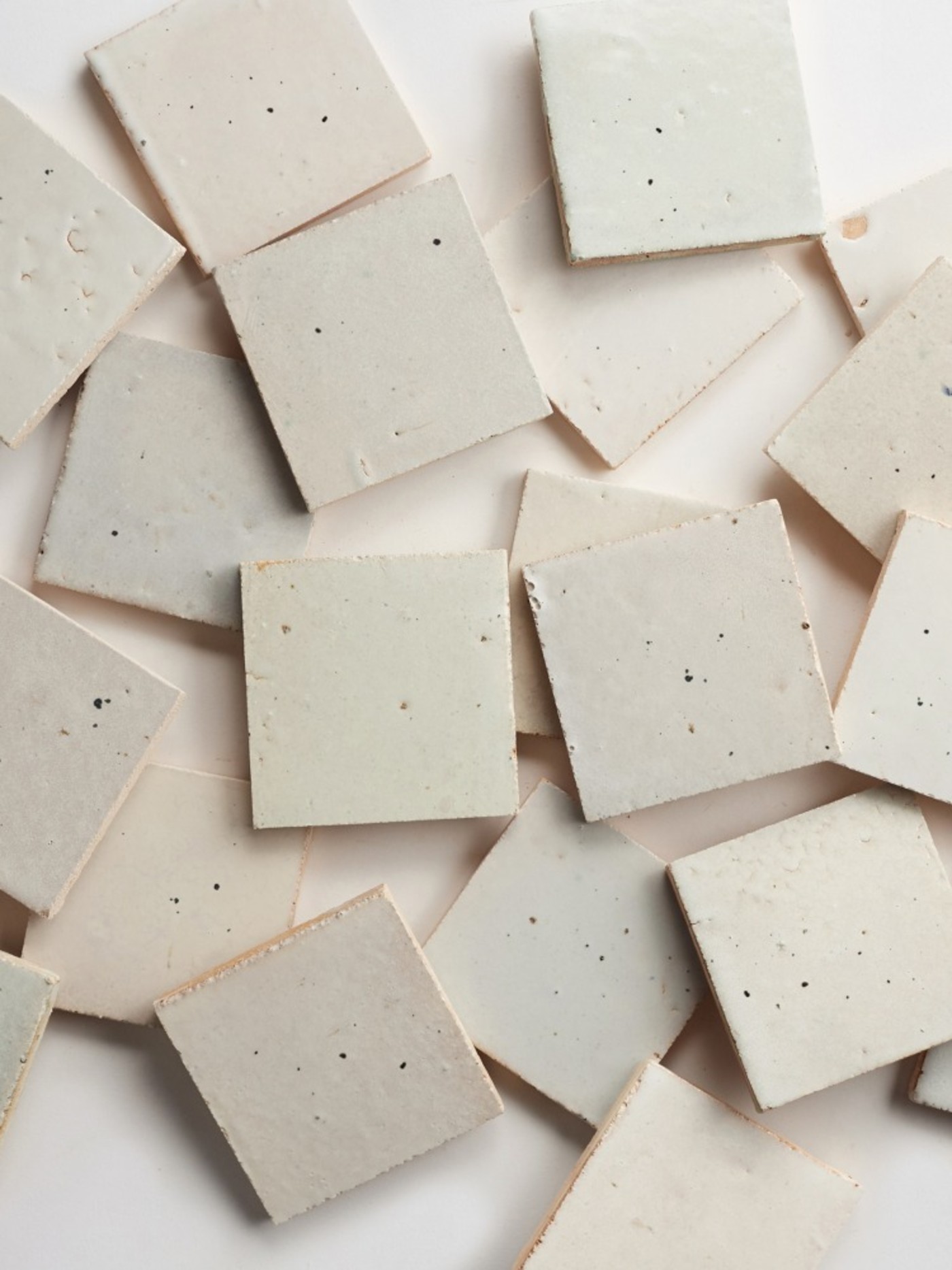 a group of white square tiles scattered on a white surface.