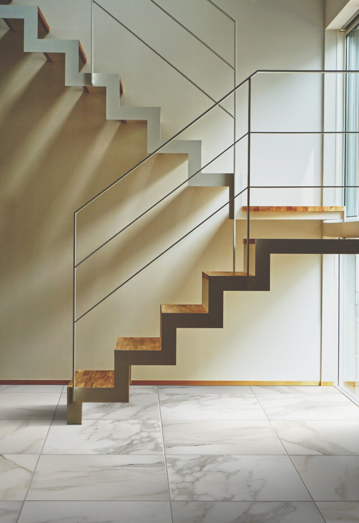 a staircase above a marble tile floor.