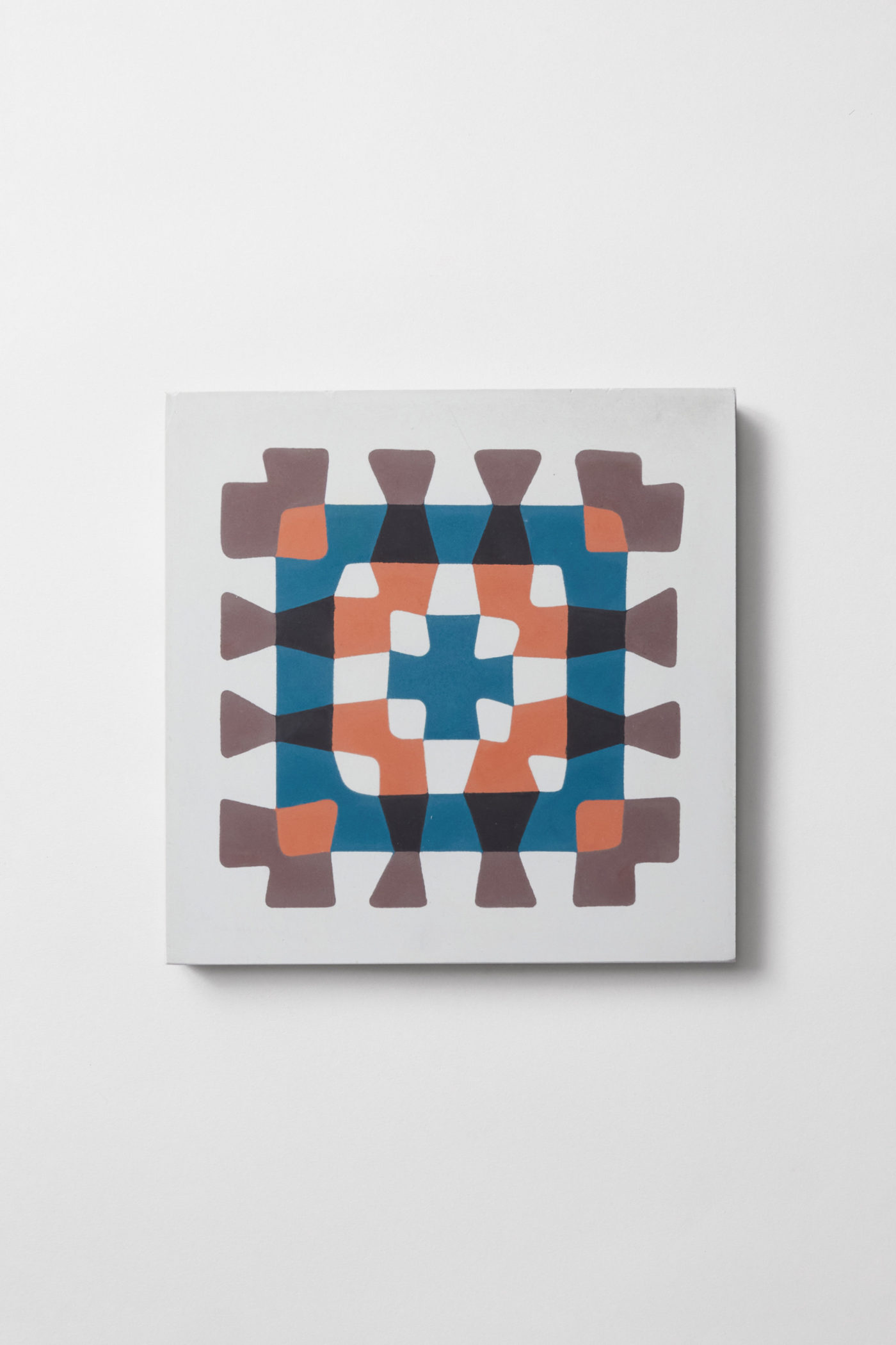 a blue, orange, and brown tile with a crochet pattern on a white surface.