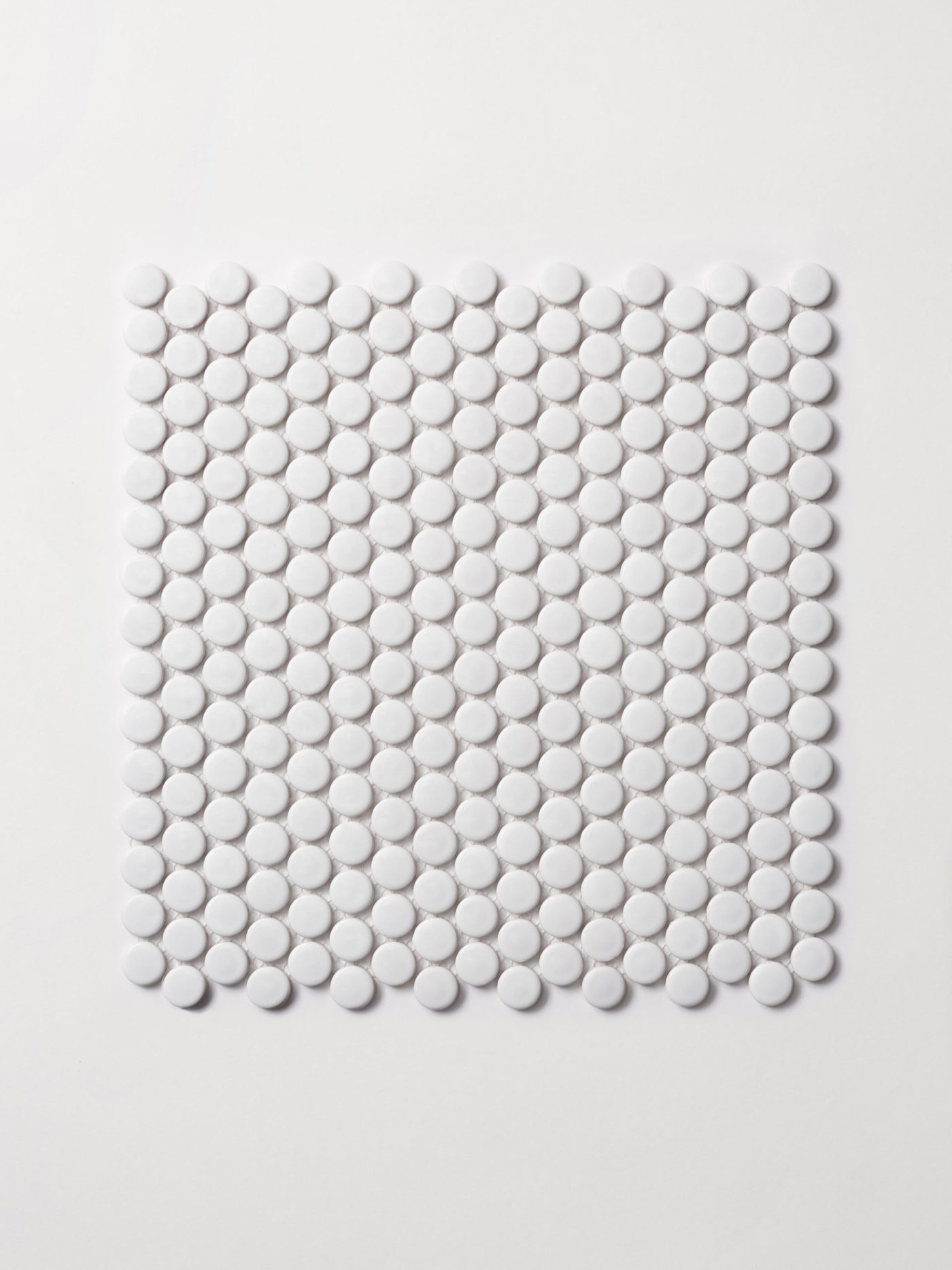 a white tile with white circles on a white surface.