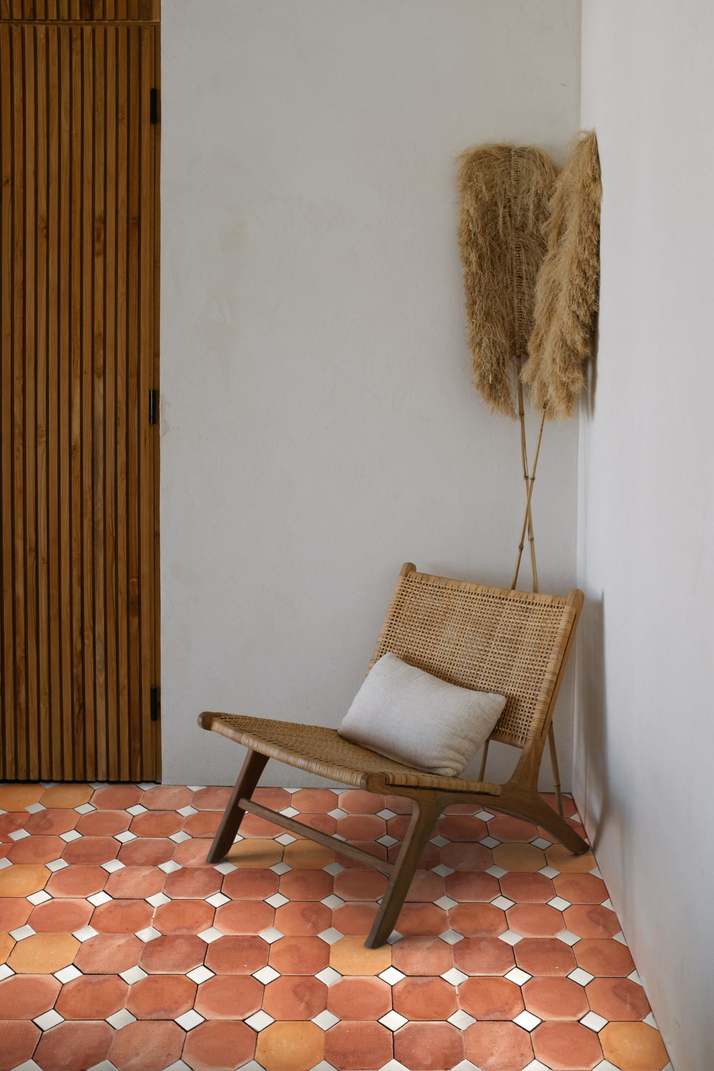 a room with an orange tile floor and a wooden chair.