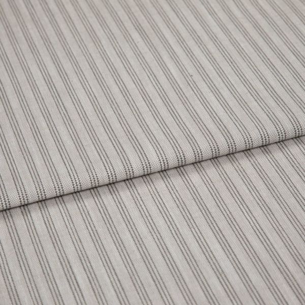 Striped cotton-blend fabric sample, narrow vertical pinstripes in gray on beige, folded once to form a layered edge; close-up studio shot showing woven texture and soft, neutral lighting.