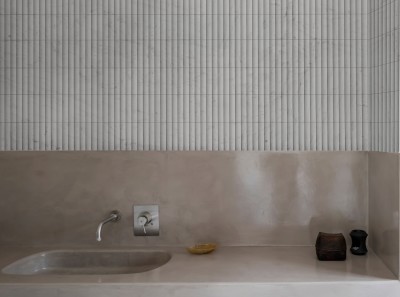 a bathroom with a white sink and tiled walls.
