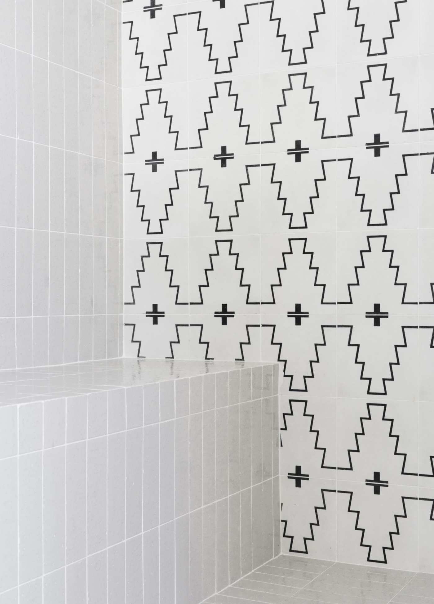 a bathroom with a black and white tiled wall.