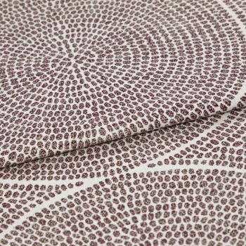 Brown-dot jacquard fabric, folded once with overlapping edge; dots form concentric circular patterns, slightly raised texture, photographed in close-up under neutral studio lighting on a pale background.