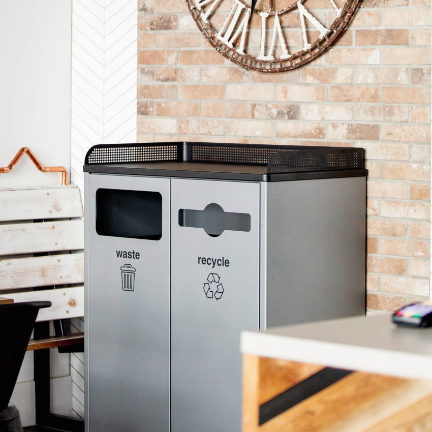 double waste and recycling container with a food tray shelf in a modern restaurant against a brick wall