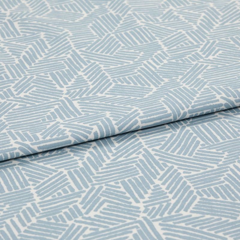 Light blue-and-white patterned fabric with geometric short parallel-stripe blocks; folded with an overlapping edge; close-up on textile surface under soft, even studio lighting.