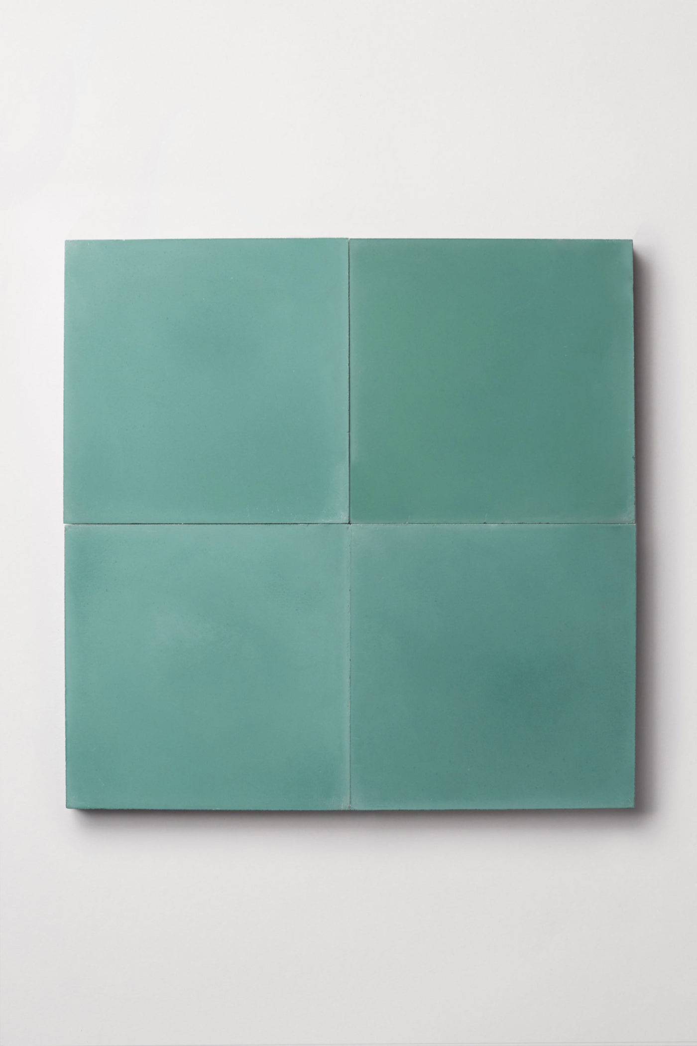 four square teal tiles on a white surface.