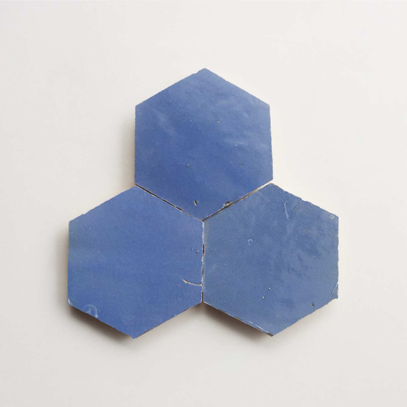 three blue hexagon tiles on a white surface.