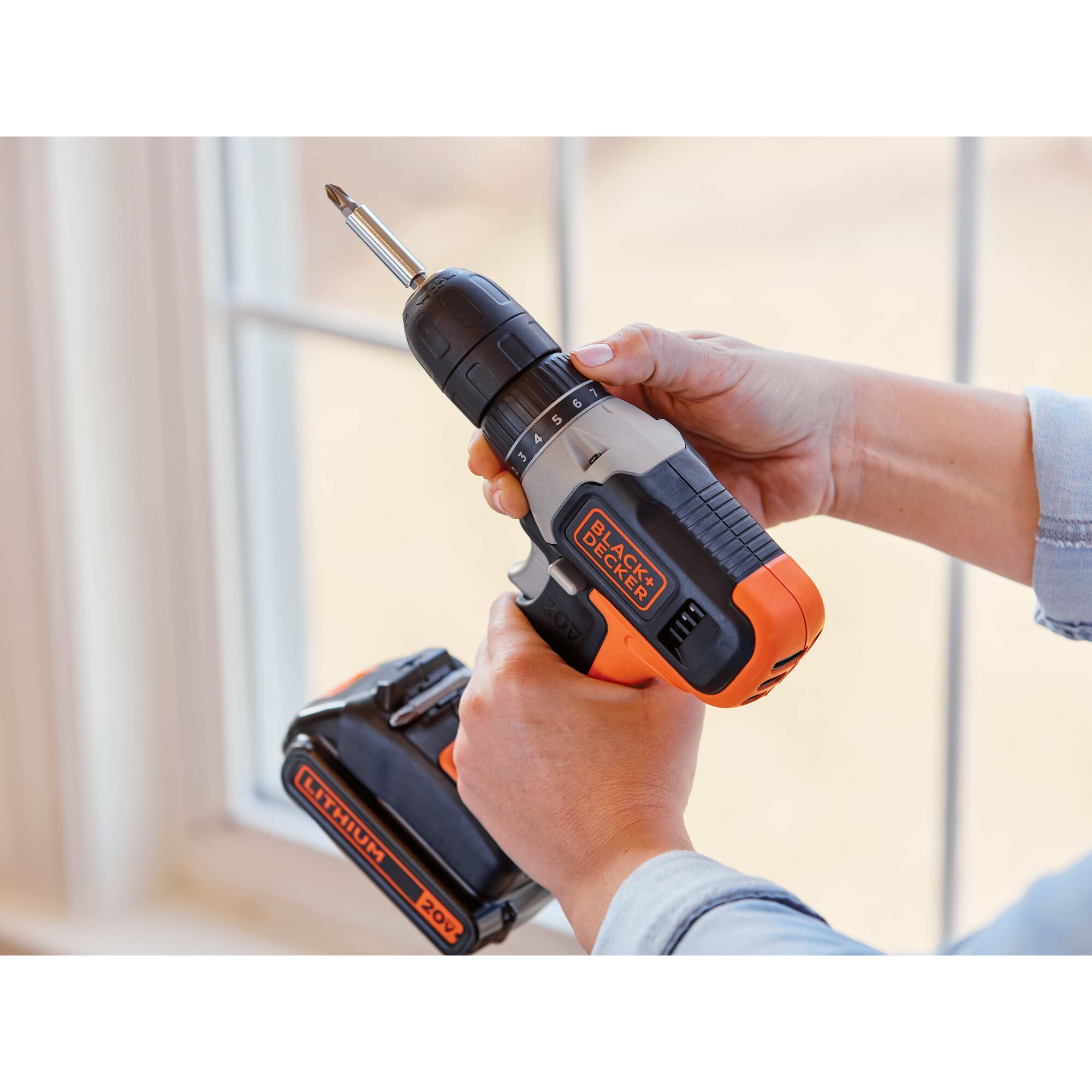 Person adjusting the chuck on a BLACK+DECKER 20 volt max drill driver that has a screwdriving bit in it