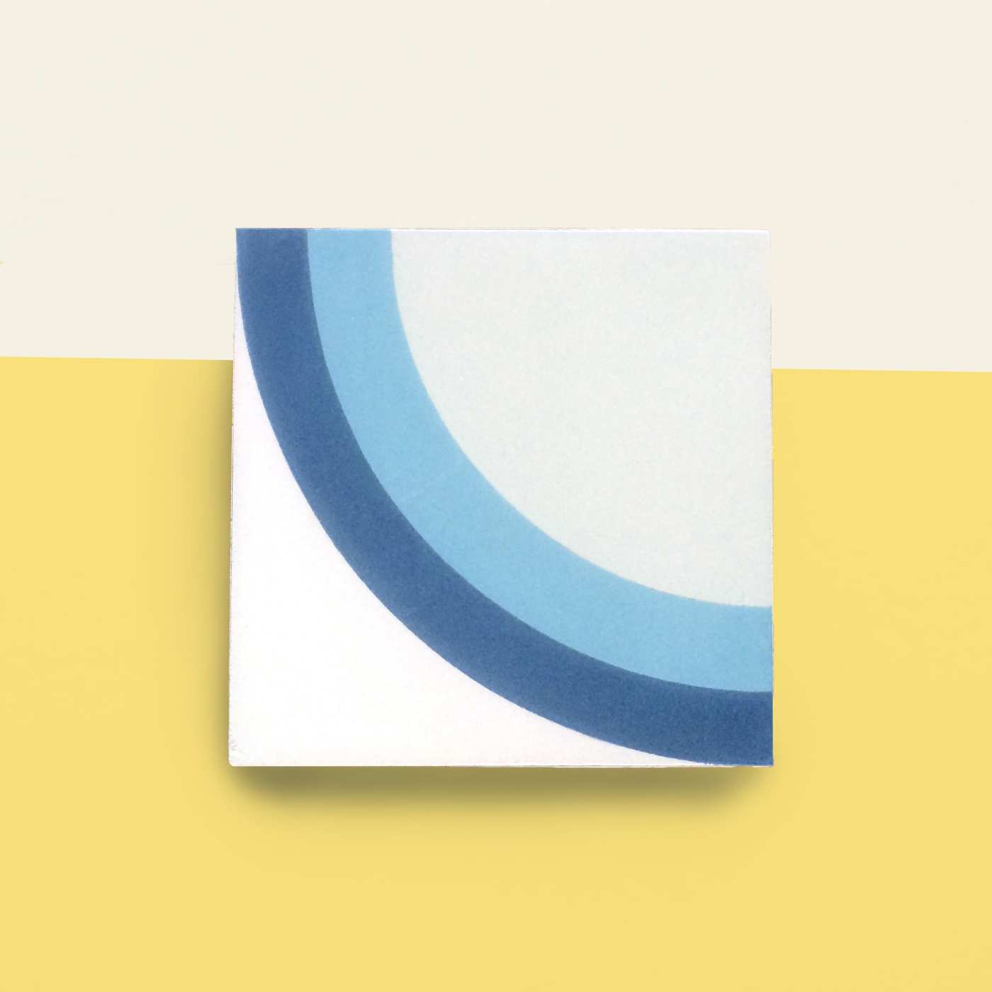 a blue and white tile on a yellow background.