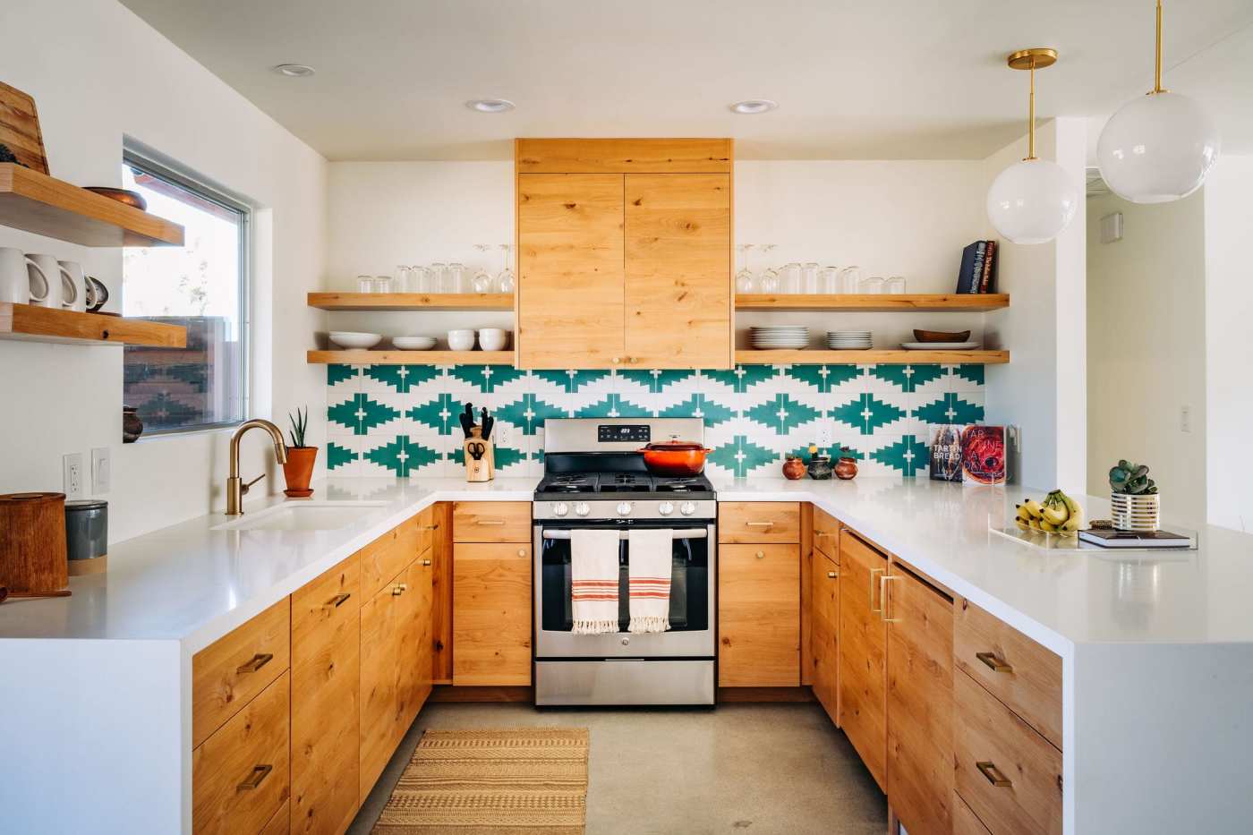 a kitchen with wooden cabinets and blue and white tiled backsplash.