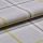 Woven plaid fabric folded to expose its edge and texture; close-up on a pale gray surface with thin yellow and dark grid lines, soft even studio lighting.