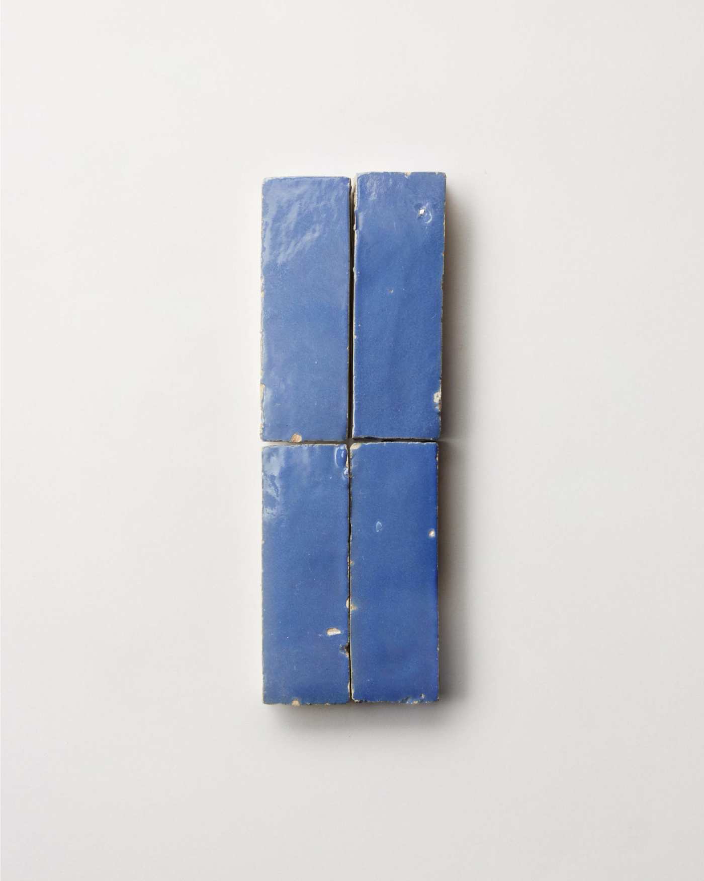 4 blue ceramic tiles on a white surface.