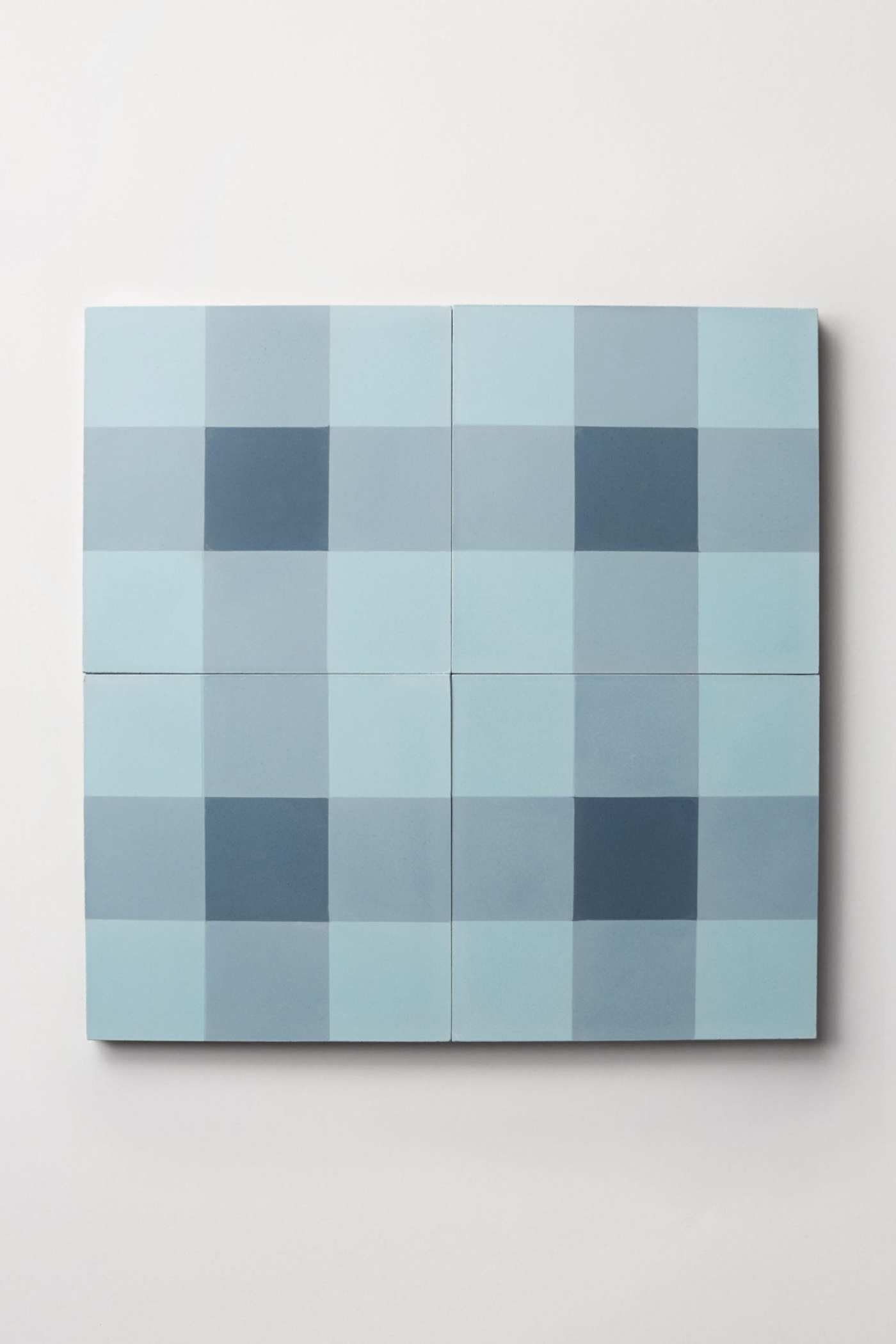 four blue and white checkered tiles on a white surface.