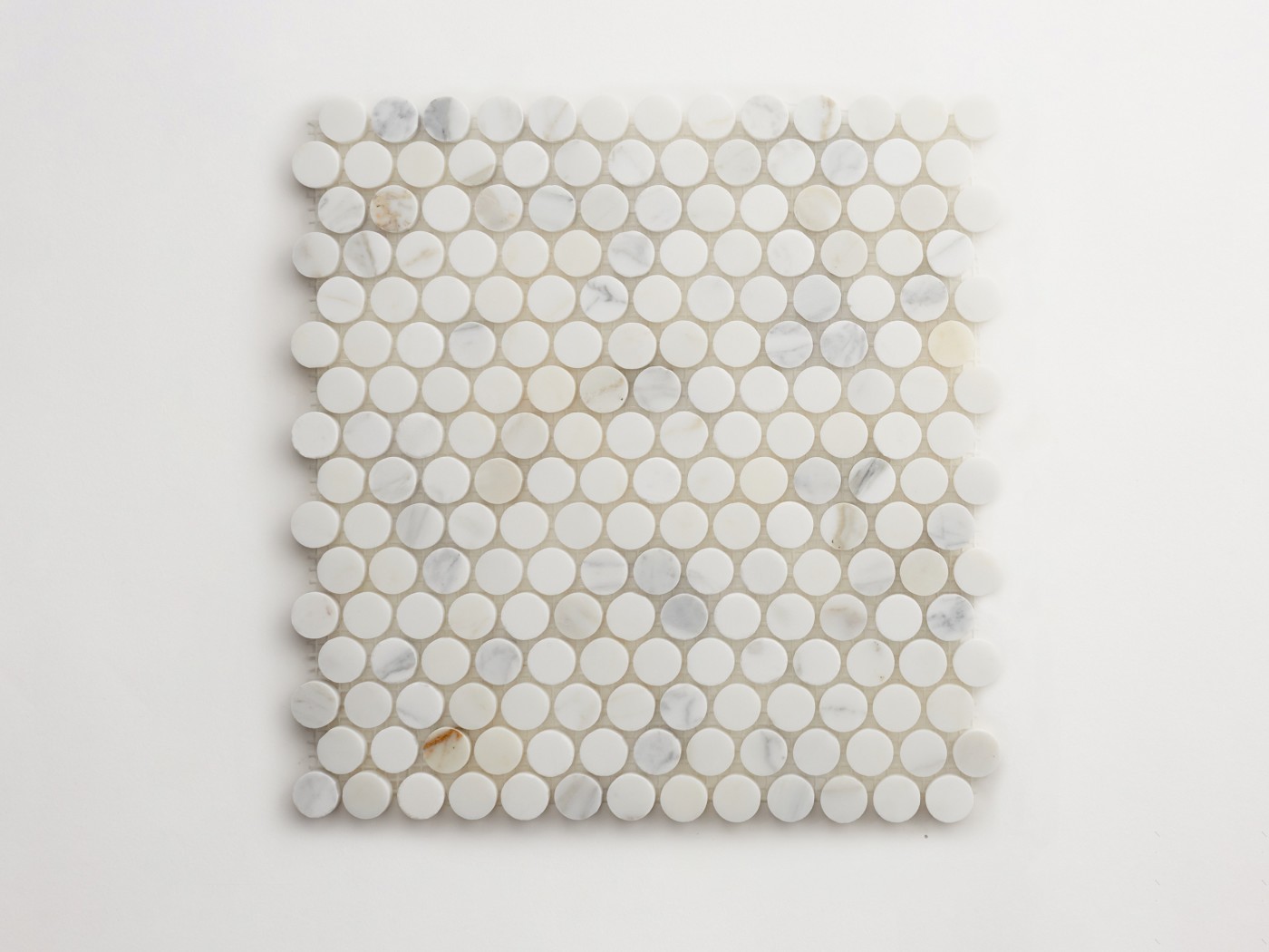 a white marble mosaic tile sheet on a white surface.