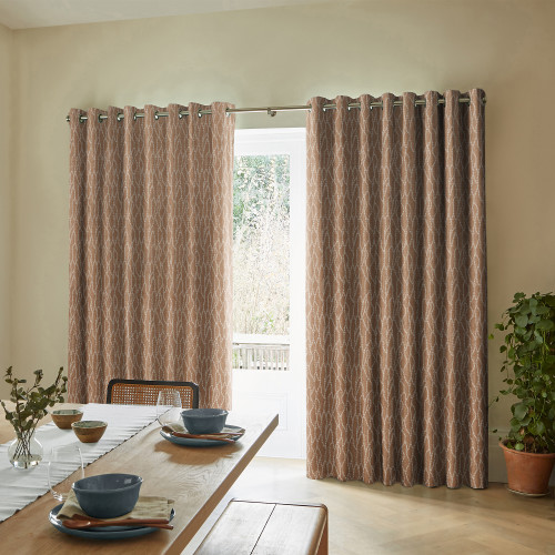 Grommet-top tan patterned floor-length curtains on a metal rod, mostly drawn with a central gap filtering daylight; dining room with a wooden table set for meals and a potted plant.