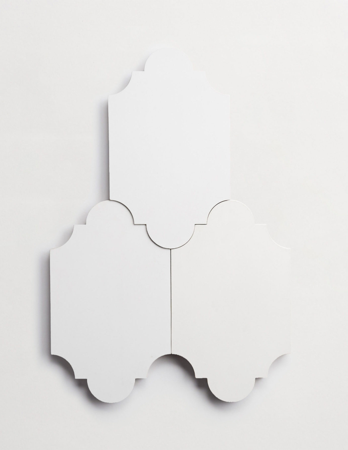 three white tiles in the shape of lanterns on a white background.