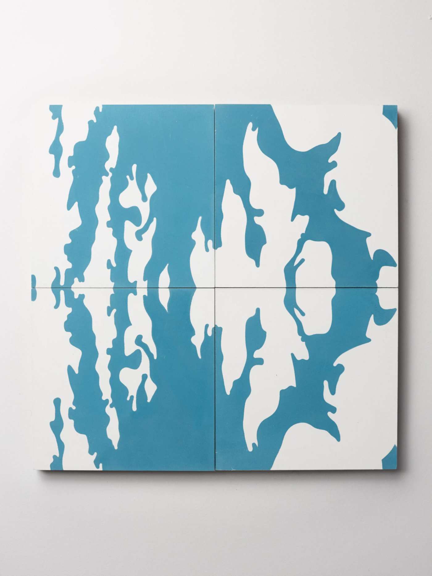 four blue and white tiles on a white surface.