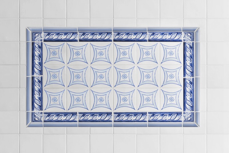 a blue and white tile pattern with a border in a bathroom.