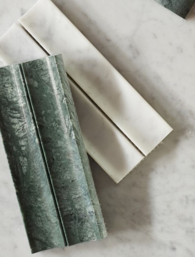 green and white marble soap bars on a marble countertop.