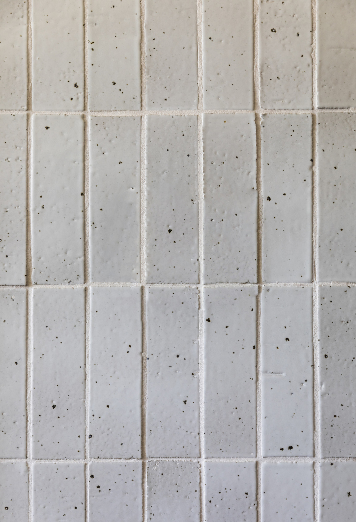 a white tiled surface with spots on it.