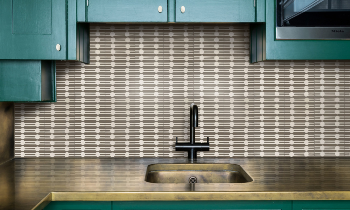 a kitchen with green cabinets and a black and white tiled sink backsplash.