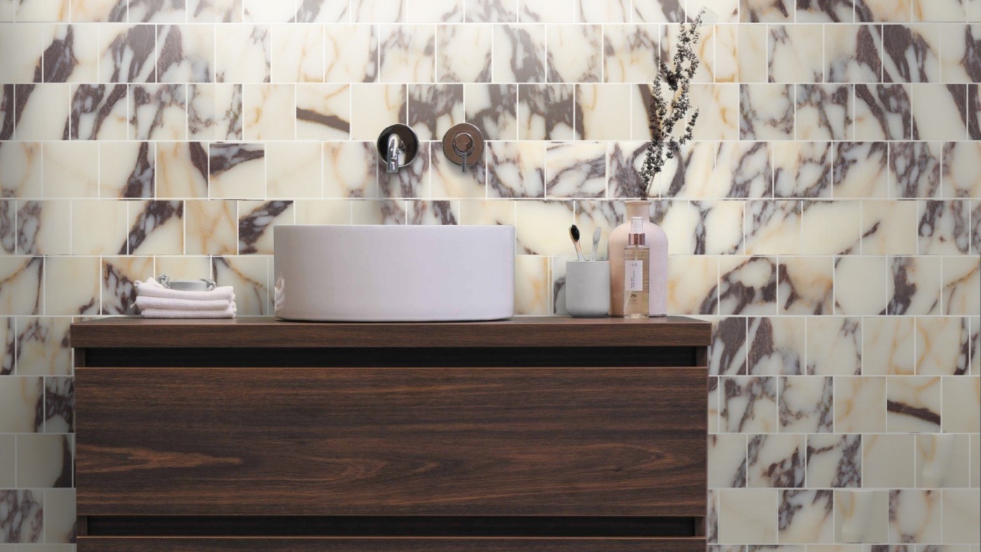 a bathroom with marble tiles and a wooden vanity.