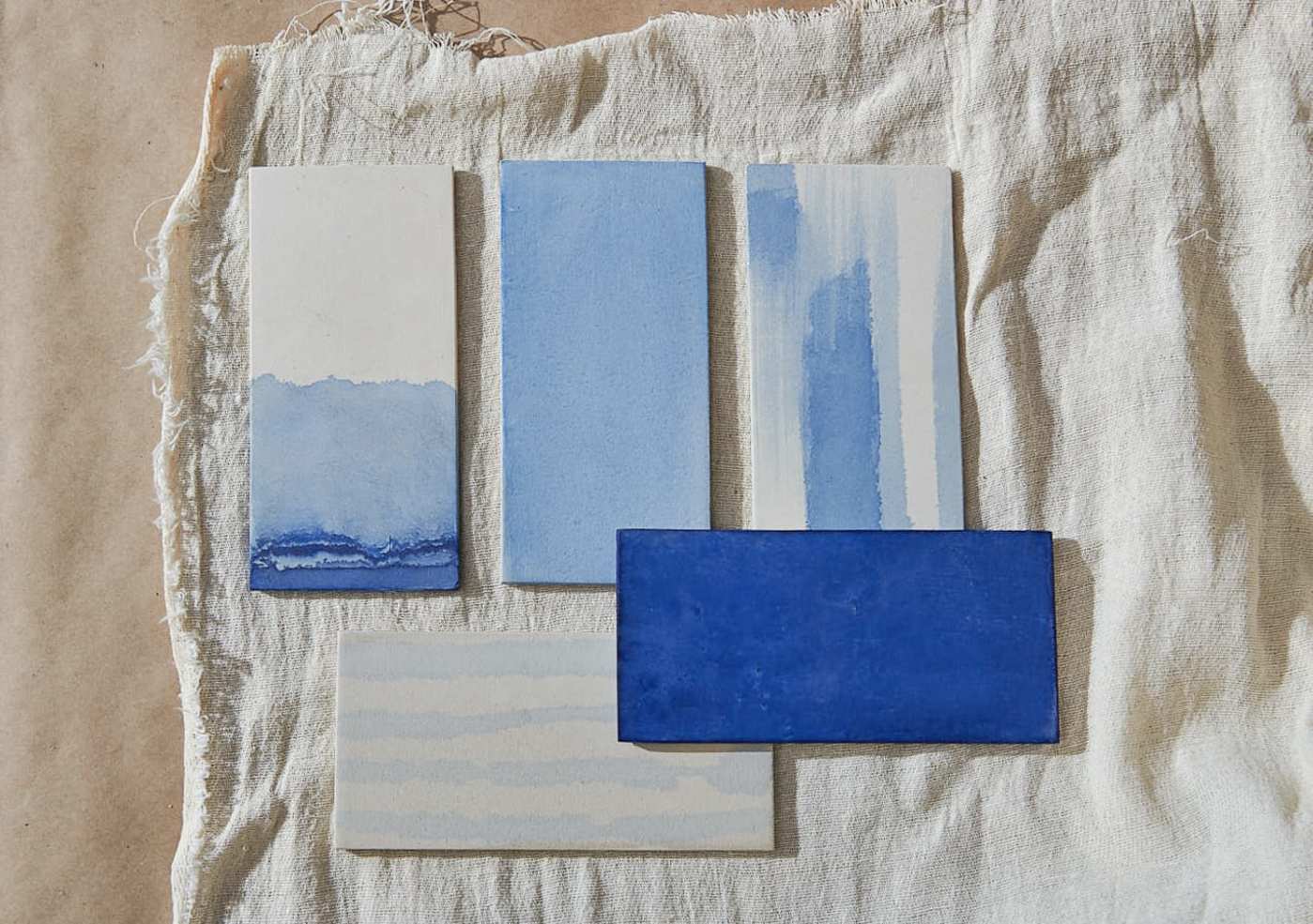 a set of blue and white tiles on a cloth.