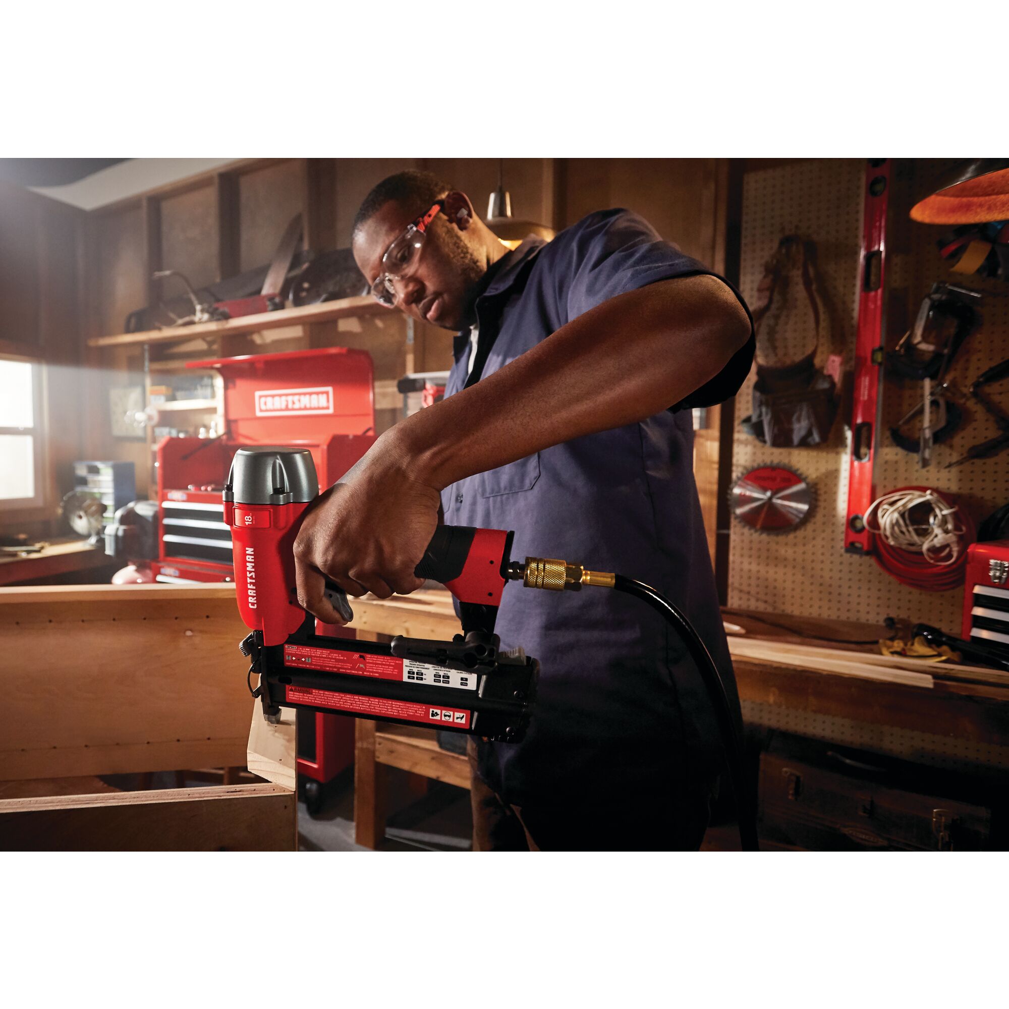 18 gauge brad nailer being used to nail a wooden strip by a person.