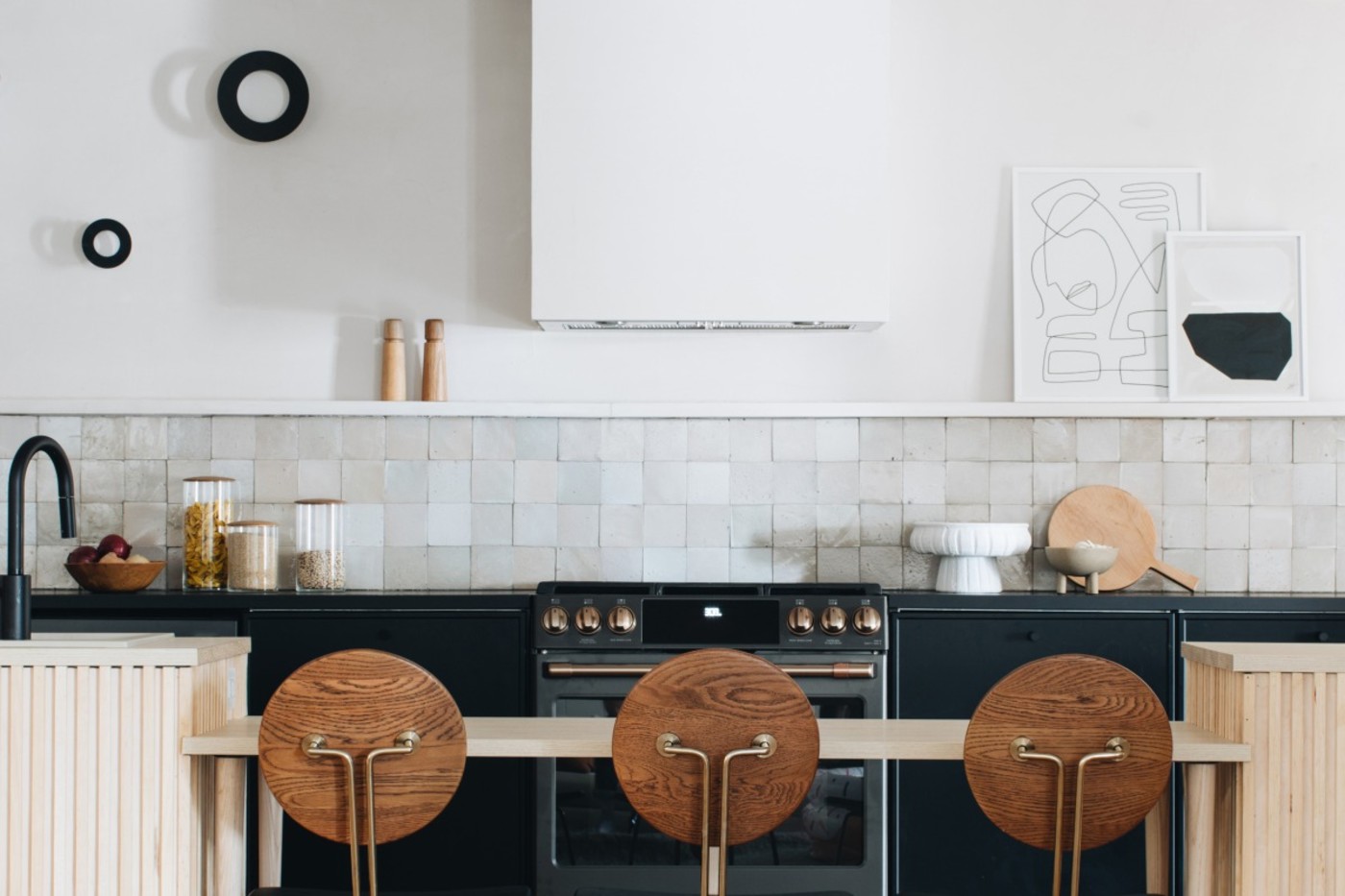 a black and white kitchen with wooden stools.