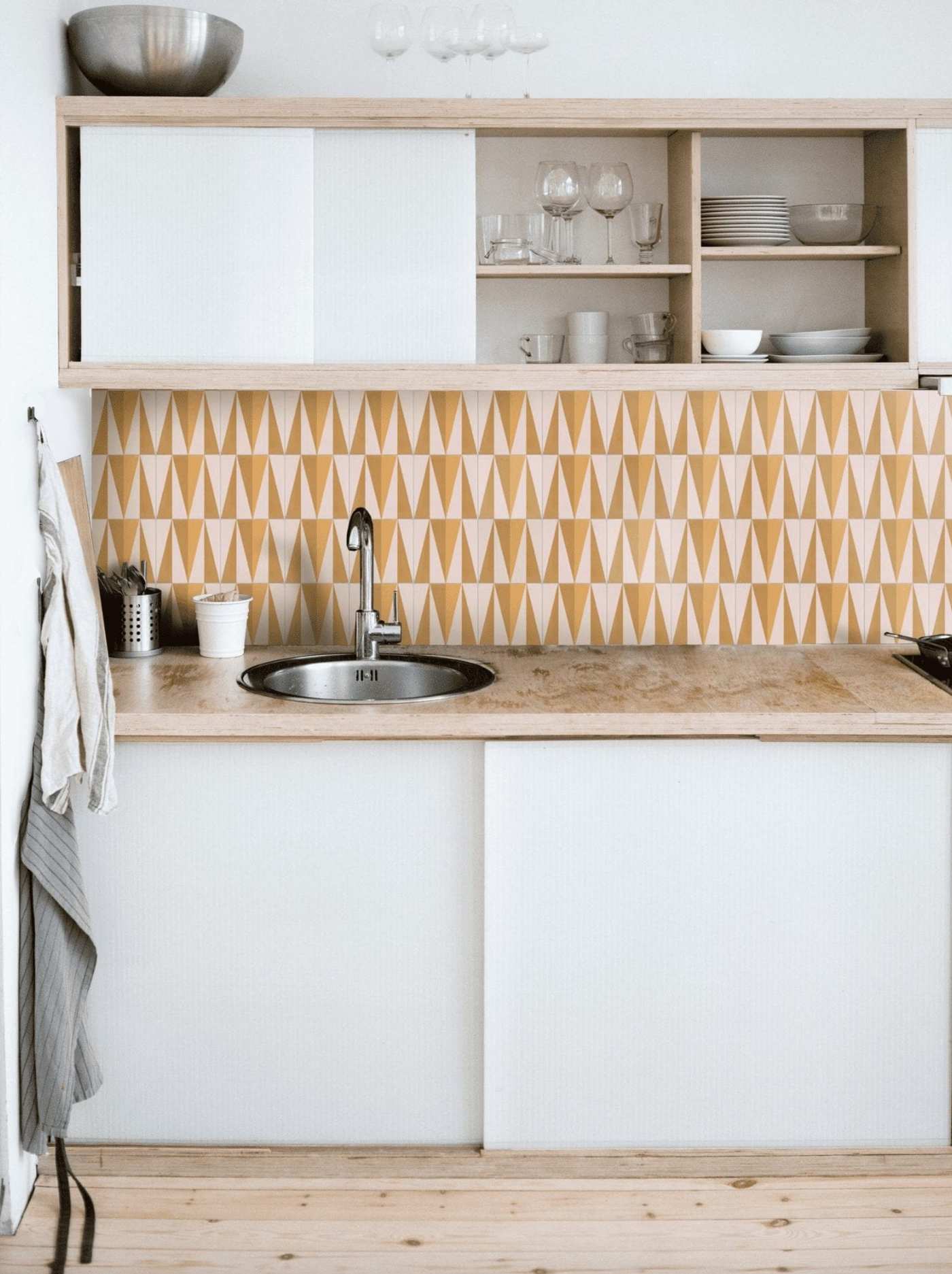 a kitchen with a yellow and white tile backsplash.