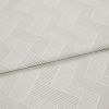 Cream textured fabric with raised linear herringbone rectangles, folded and overlapping across the frame, showing ribbed weave detail in a close-up product shot with soft, diffuse lighting.