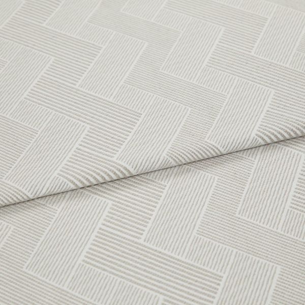 Cream textured fabric with raised linear herringbone rectangles, folded and overlapping across the frame, showing ribbed weave detail in a close-up product shot with soft, diffuse lighting.