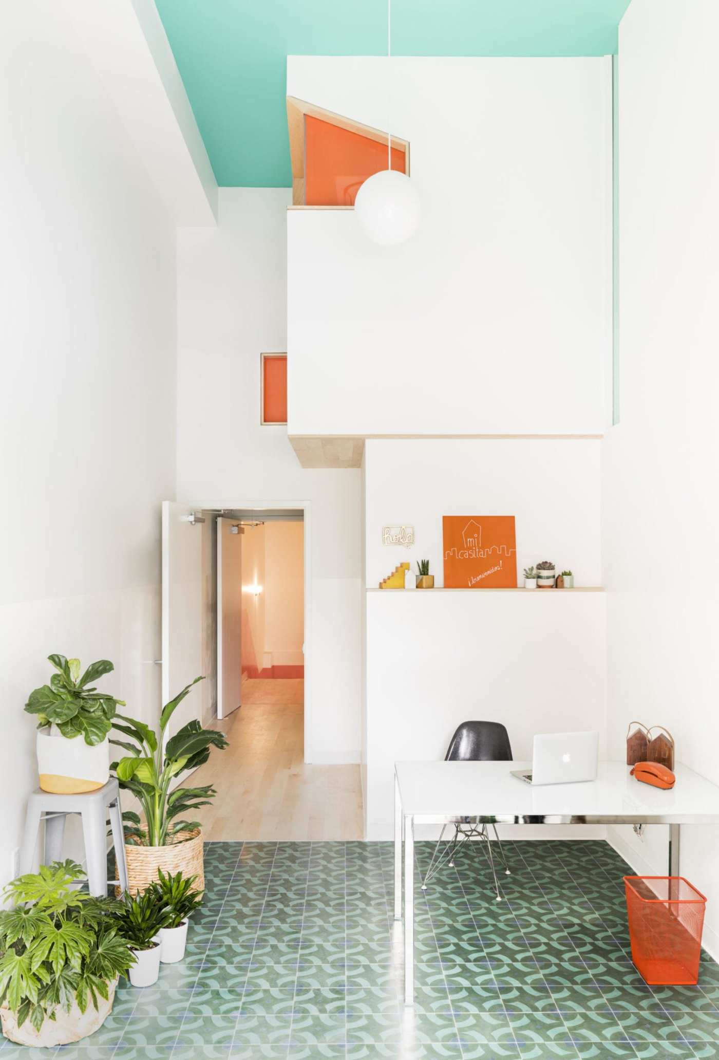 an orange and green office with a desk and plants.