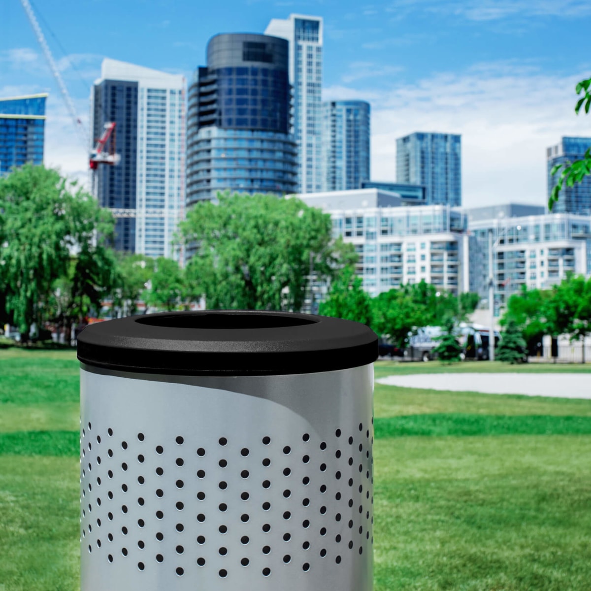 silver powder coated steel recycling bin with a blue liner and blue full opening lid outdoors on a busy city sidewalk with people walking by