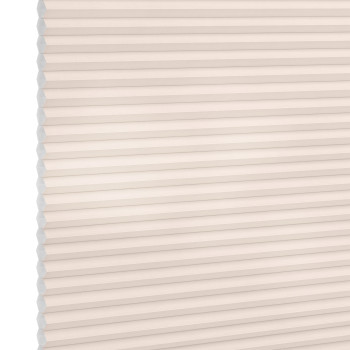Cellular (honeycomb) pleated blind, cream-colored, fully lowered and closed with visible hexagonal cells; diffusing soft light across a plain interior wall, suggesting a bright, neutral room.