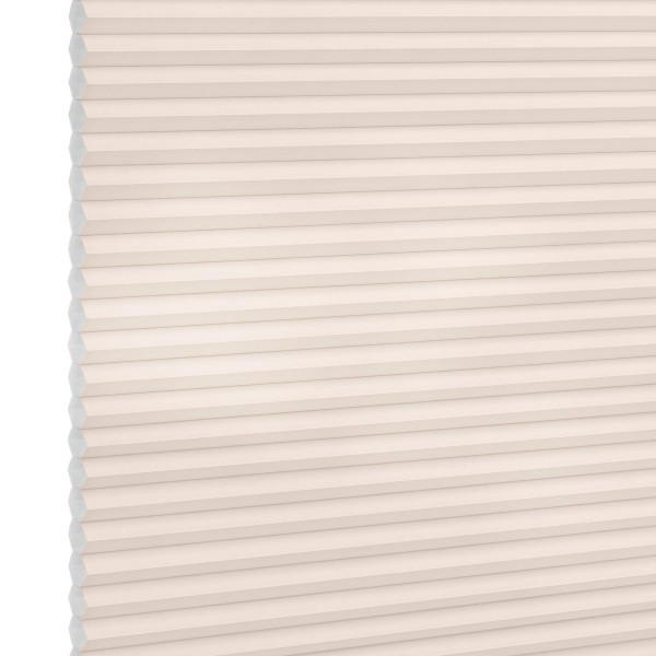 Cellular (honeycomb) pleated blind, cream-colored, fully lowered and closed with visible hexagonal cells; diffusing soft light across a plain interior wall, suggesting a bright, neutral room.