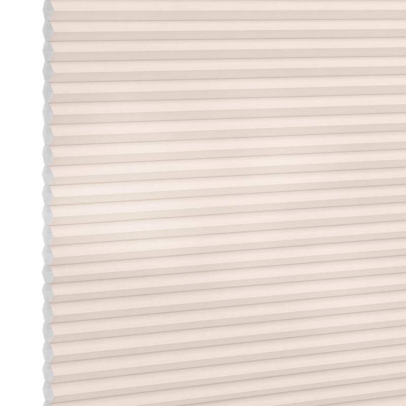 Cellular (honeycomb) pleated blind, cream-colored, fully lowered and closed with visible hexagonal cells; diffusing soft light across a plain interior wall, suggesting a bright, neutral room.