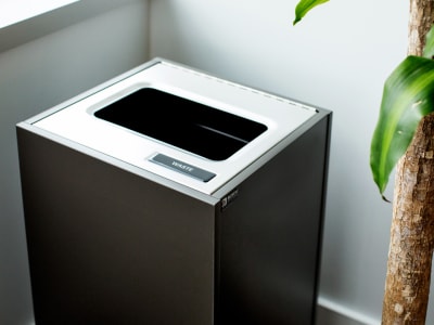 single stream high-end waste container with stainless stee lid and slate melamine body in an office environment