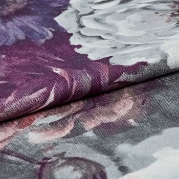 Folded floral-printed canvas fabric (textured weave), edge overlapping and creating a ridge; showing white and purple peony-like petals in a close-up macro view with soft, even lighting.