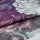 Folded floral-printed canvas fabric (textured weave), edge overlapping and creating a ridge; showing white and purple peony-like petals in a close-up macro view with soft, even lighting.