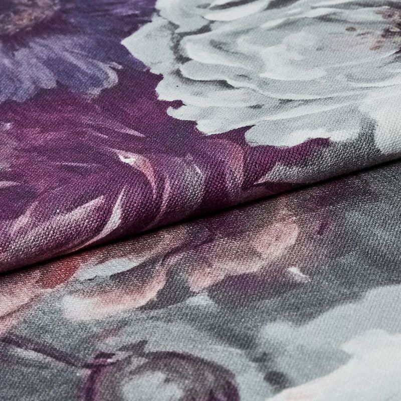 Folded floral-printed canvas fabric (textured weave), edge overlapping and creating a ridge; showing white and purple peony-like petals in a close-up macro view with soft, even lighting.