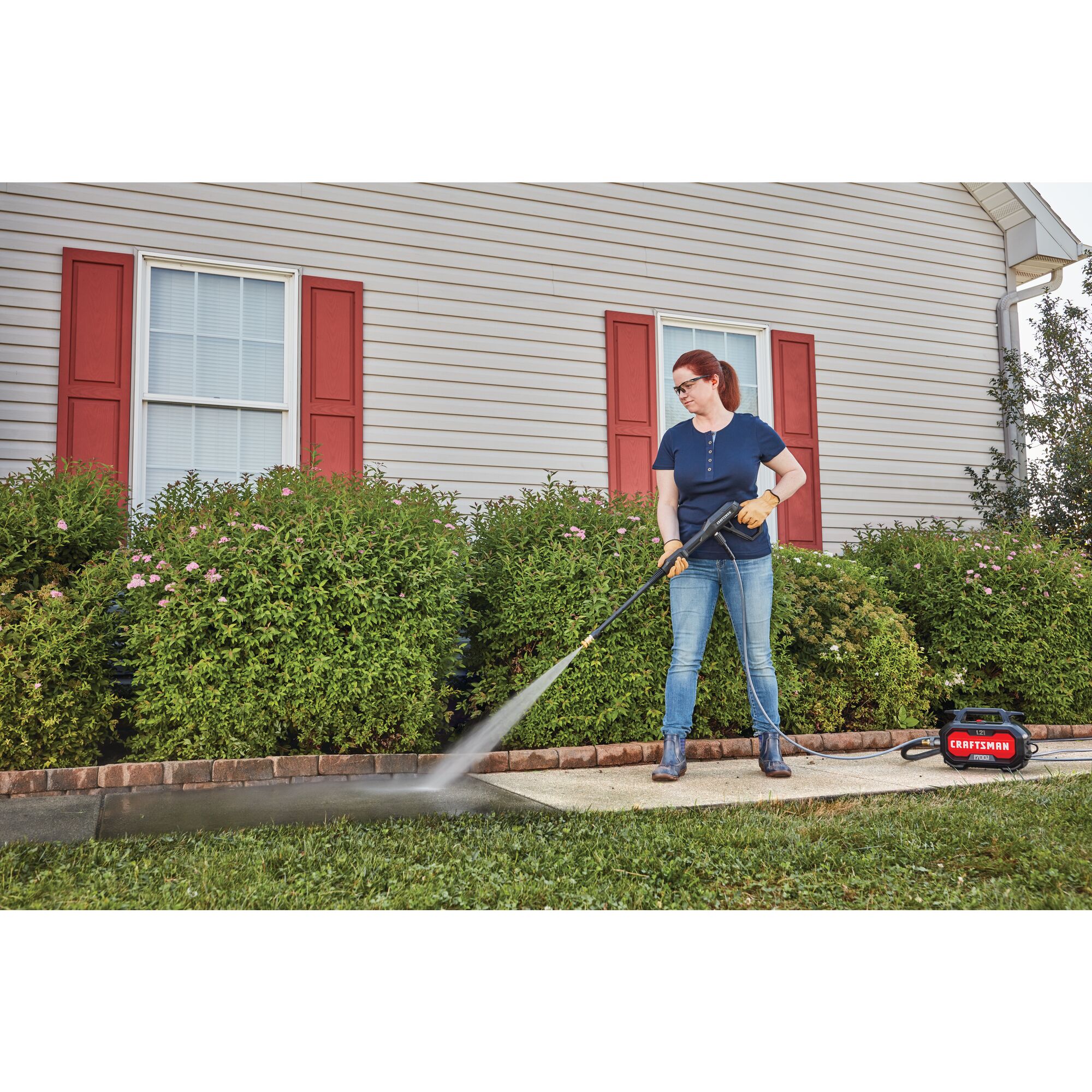 1700 pound per square inch electric compact cold water pressure washer being used by a person.