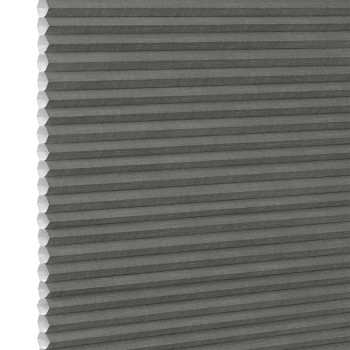 Gray cellular (honeycomb) pleated blind, fully lowered and closed, blocking light; close-up interior view showing textured fabric and white left-side gap under neutral lighting.