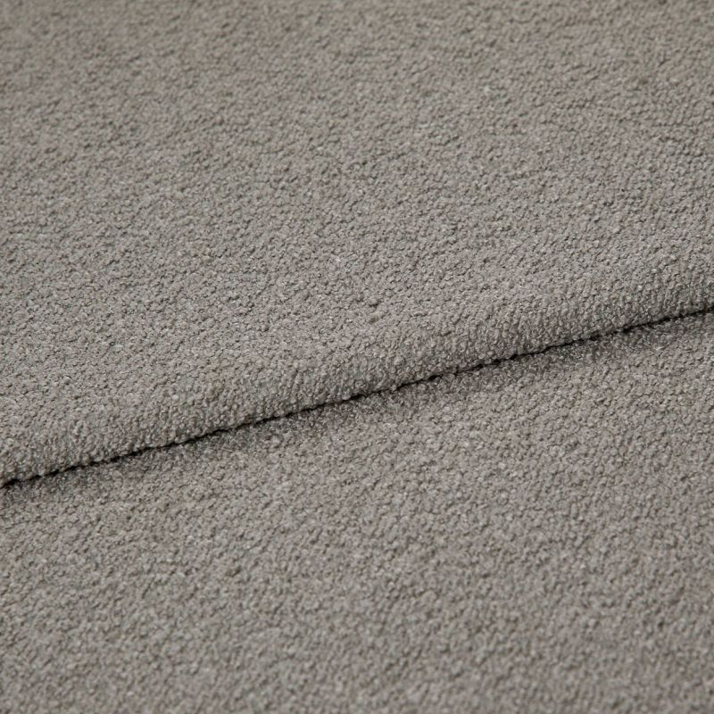 Gray boucle upholstery fabric folded to show an overlapping edge; dense looped texture; close-up, evenly lit studio view of a neutral-colored textile surface.