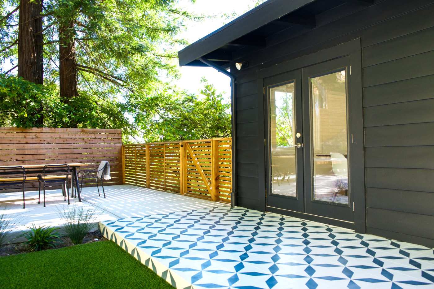 a blue and white tiled patio with a table and chairs.