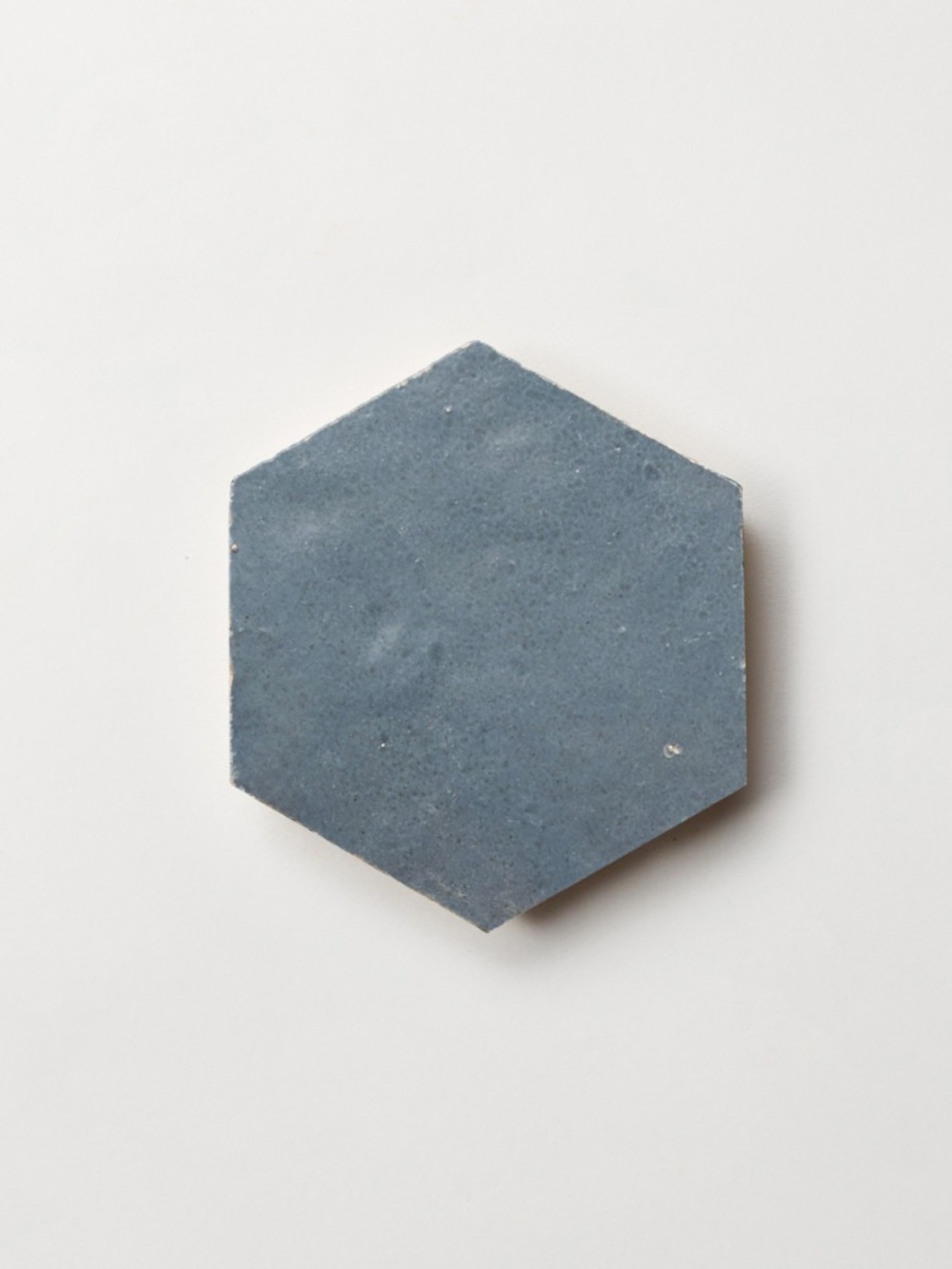 a blue hexagonal tile on a white surface.